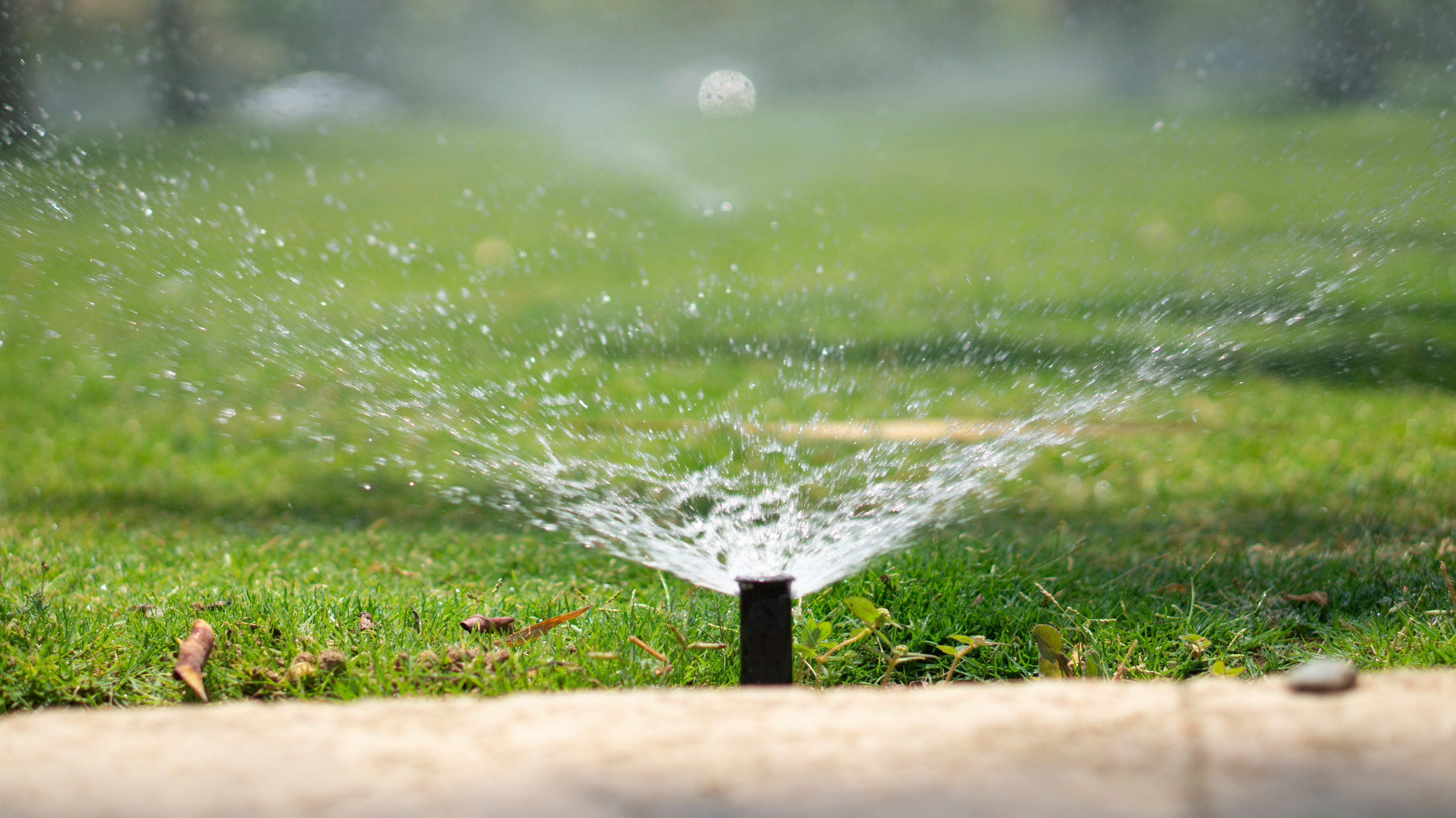 Sprinkler system watering a lush green lawn